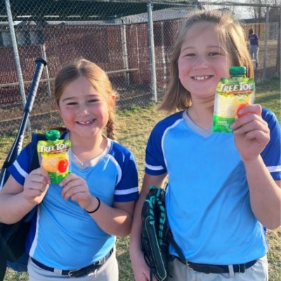Two kids playing baseball holding Tree Top apple sauce pouches
