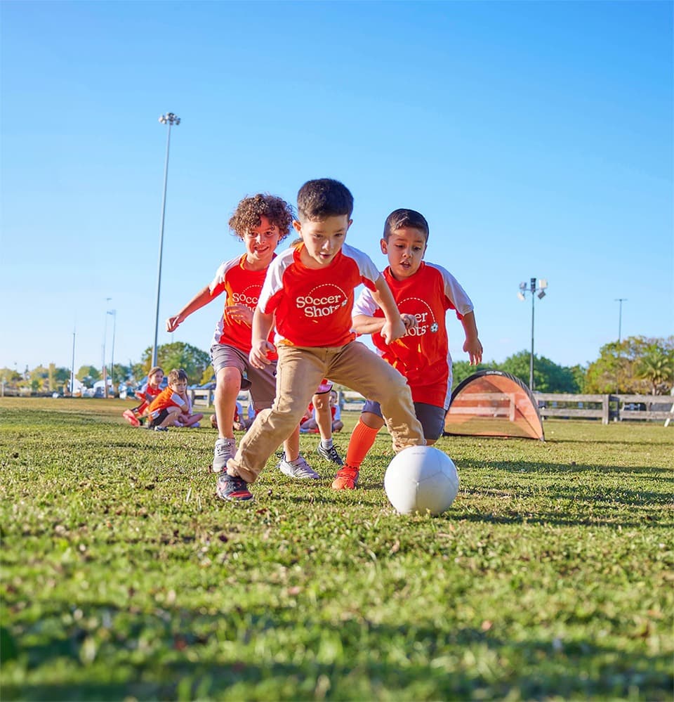 Three children playing with a soccer ball