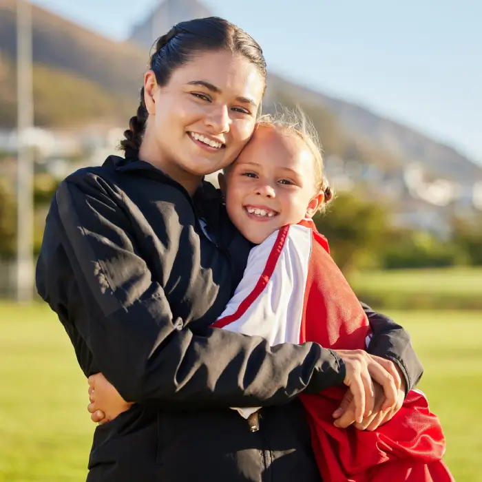 Mom and daughter embrace at soccer practice